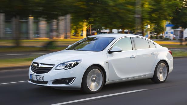 Ein weißer Opel Insignia fährt auf einer Straße.
