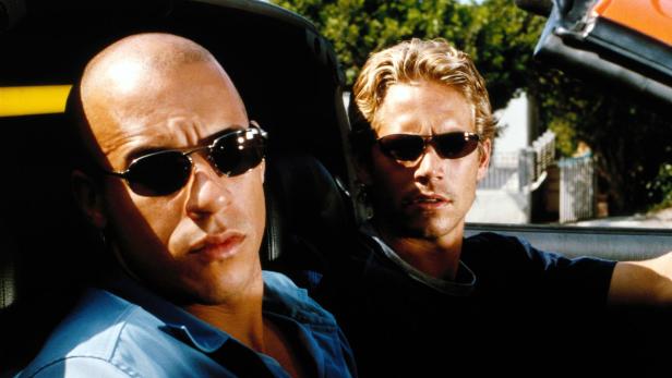 Vin Diesel und Paul Walker sitzen in einem Auto und tragen Sonnenbrillen.