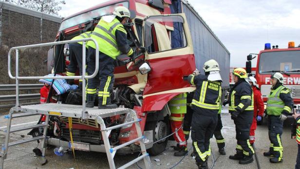 Ein verunglückter Lastwagen wird von Feuerwehrleuten begutachtet.