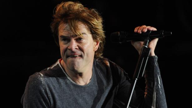 Richie Sambora singt während eines Konzerts in ein Mikrofon.