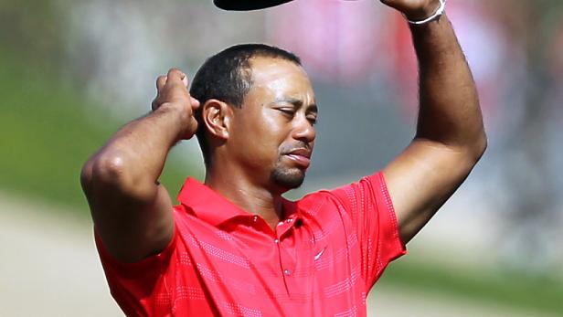 Tiger Woods nimmt seine Mütze ab.