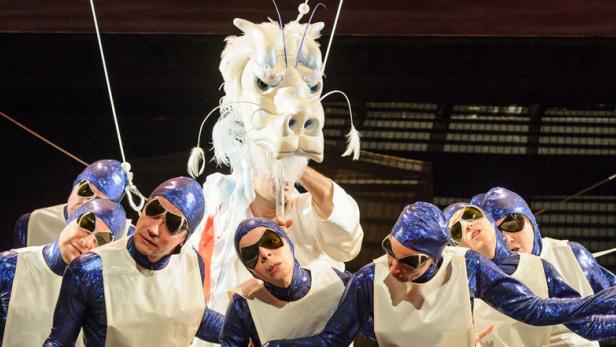 Eine Gruppe von Darstellern mit einem weißen Drachen auf einer Bühne.