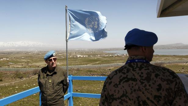 Peacekeeping troops from the unarmed United Nations Truce Supervision Organisation (R) (UNTSO) and the UN Disengagement Observer Force (L) (UNDOF) stand on an observation tower located on the Israeli side of the 1973 Golan Heights ceasefire line with Syria March 21, 2012. Blue-helmeted United Nations peacekeeping troops patrolling a slice of Syrian territory to maintain a ceasefire with Israel face new risks as violence between Syrian government loyalists and rebels gets closer. Picture taken March 21, 2012. REUTERS/Ronen Zvulun (POLITICS CONFLICT MILITARY)