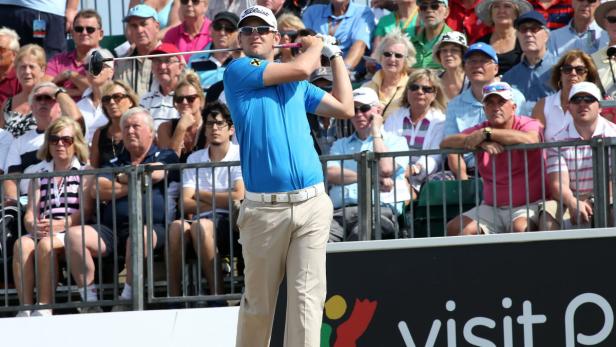 Ein Golfspieler schlägt vor einer Zuschauermenge ab.
