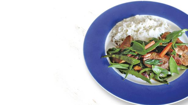 Ein Teller mit Reis, Fleisch und Gemüse, darunter grüne Bohnen und Karotten.