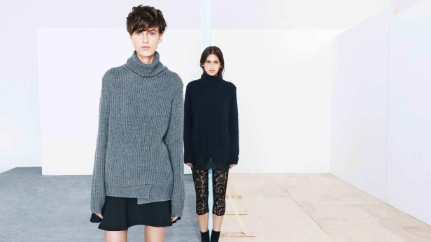 Zwei Frauen posieren in Rollkragenpullovern und Röcken vor einem minimalistischen Hintergrund.