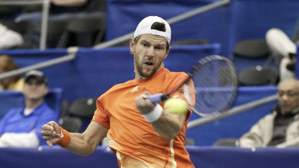 Ein Tennisspieler schlägt einen Ball mit seinem Schläger.
