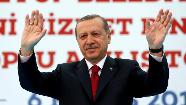Recep Tayyip Erdoğan winkt mit beiden Händen in die Menge.