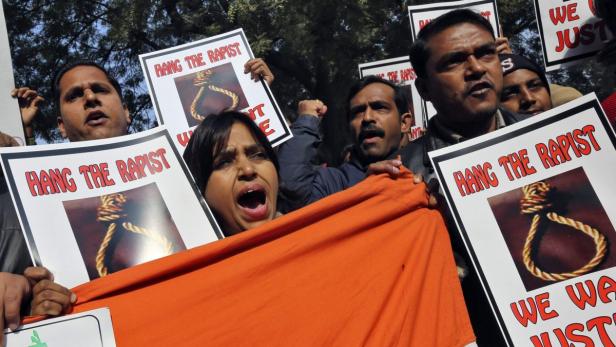 People shout slogans and hold placards during a protest in New Delhi December 29, 2012. An Indian woman whose gang rape in New Delhi triggered violent protests died of her injuries on Saturday in a Singapore hospital, bringing a security lockdown in Delhi and recognition from India&#039;s prime minister that social change is needed. REUTERS/Adnan Abidi (INDIA - Tags: CIVIL UNREST CRIME LAW TPX IMAGES OF THE DAY)