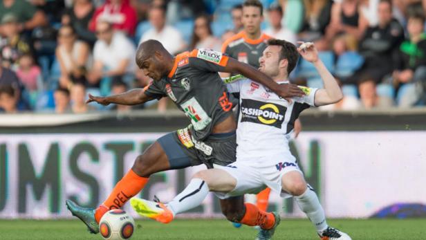 Zwei Fußballspieler kämpfen um den Ball während eines Spiels.