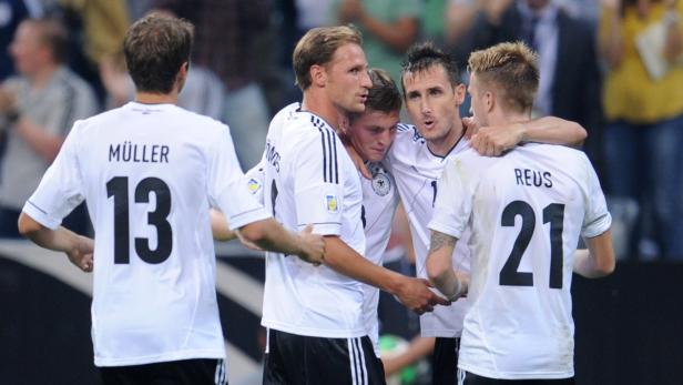 Mehrere deutsche Fußballspieler umarmen sich auf dem Spielfeld.