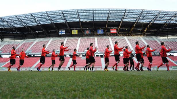 Eine Fußballmannschaft dehnt sich vor einem Spiel in einem Stadion.