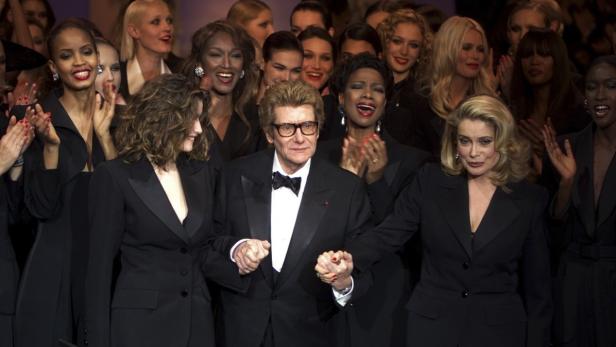 Yves Saint Laurent mit Models und Catherine Deneuve bei einer Modenschau.