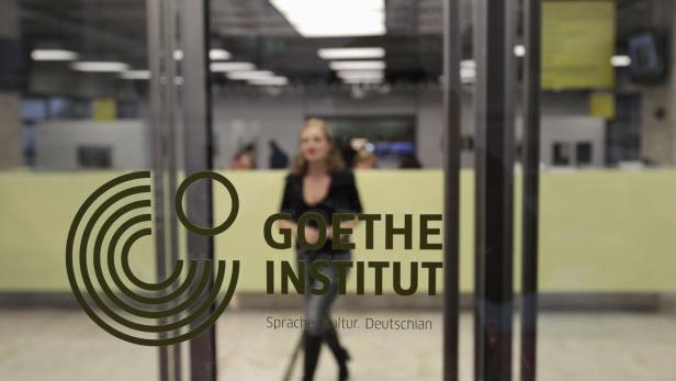 Eine Frau betritt ein Gebäude des Goethe-Instituts.