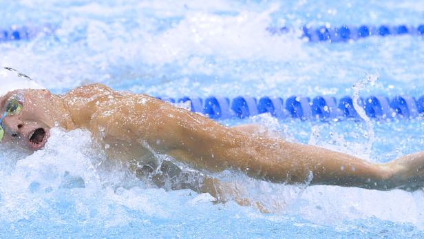 Bademeister. Der österreichische Schwimmer Dinko Jukic weiß nichts von einer Dopingprobe und kann leider nicht Wasser lassen, als er am Beckenrand von den Kontrolloren erwartet wird.
