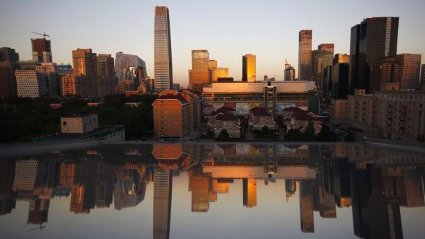 Residential and commercial buildings are seen reflected in a window during a sunset in Central Business District (CBD) of Beijing September 19, 2012. China&#039;s home prices showed a modest increase for a second consecutive month in August, rising 0.1 percent from July, signalling a gentle recovery in the property market. Nevertheless, China appears on track for a seventh quarter of slowing growth in the third quarter this year, despite a number of measures designed to encourage private investment and infrastructure construction while avoiding a further pile-up in local government debt. Picture taken September 19, 2012. REUTERS/David Gray (CHINA - Tags: REAL ESTATE BUSINESS CITYSPACE)
