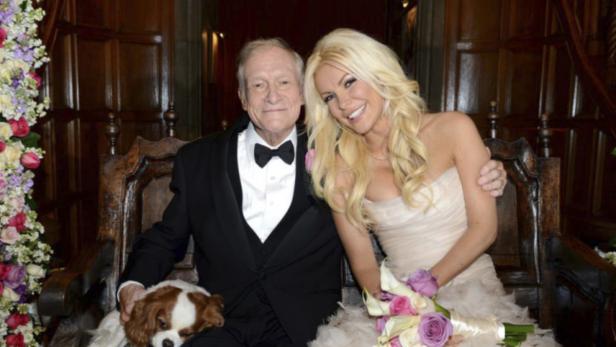 Octogenarian Playboy founder Hugh Hefner poses with his bride Crystal Harris and dog Charlie at their New Year Eve wedding at the Playboy Mansion in Beverly Hills, California in this handout photo taken on December 31, 2012. Hefner briefly swapped his iconic silk pajamas for a tuxedo to marry Harris, the one-time &quot;runaway bride&quot; who followed through this time at the New Year&#039;s Eve wedding. The couple tied the knot more than a year after their planned 2011 wedding was scuttled when Harris got cold feet. REUTERS/Elayne Lodge/PEI/Handout (UNITED STATES - Tags: ENTERTAINMENT MEDIA TPX IMAGES OF THE DAY) FOR EDITORIAL USE ONLY. NOT FOR SALE FOR MARKETING OR ADVERTISING CAMPAIGNS. THIS IMAGE HAS BEEN SUPPLIED BY A THIRD PARTY. IT IS DISTRIBUTED, EXACTLY AS RECEIVED BY REUTERS, AS A SERVICE TO CLIENTS. NO ARCHIVES. NO SALES