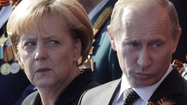 Angela Merkel und Wladimir Putin stehen nebeneinander.