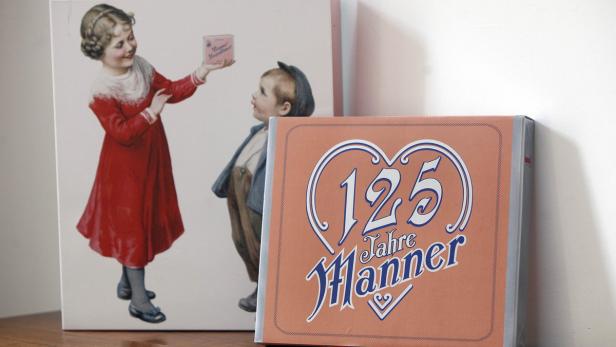 Eine Jubiläumspackung Manner-Schnitten vor einem nostalgischen Manner-Werbebild.