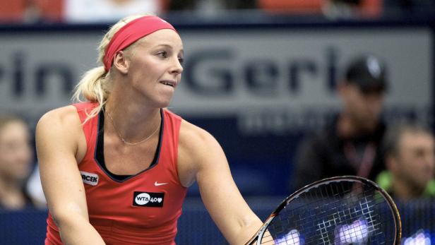 Eine Tennisspielerin mit rotem Stirnband während eines Matches.
