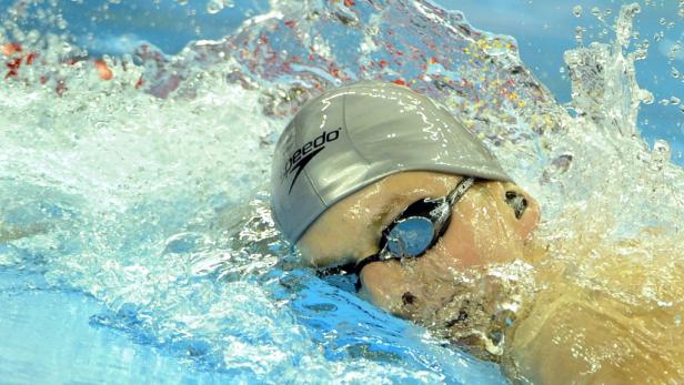 Ein Schwimmer mit Badekappe und Schwimmbrille im Wasser.