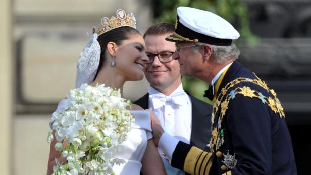 epa02211779 Crown Princess Victoria of Sweden (L) receives a kiss from her father, King Carl XVI Gustaf (R) of Sweden as Prince Daniel Westling, Duke of Vastergotland (C) looks on on the balcony of the Royal Palace in Stockholm, Sweden, 19 June 2010, after their wedding ceremony at Stockholm&#039;s Storkyrkan cathedral. The bridal couple shares the June 19 wedding date with Princess Victoria&#039;s parents, King Carl XVI Gustaf and Queen Silvia, who married on 19 June 1976 in the same cathedral. EPA/JOCHEN LUEBKE
