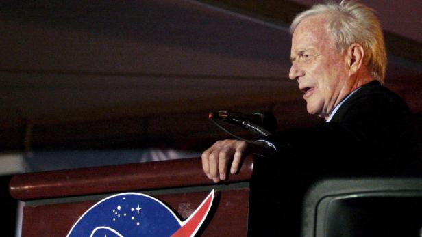 Ein Mann spricht am Rednerpult mit dem NASA-Logo.