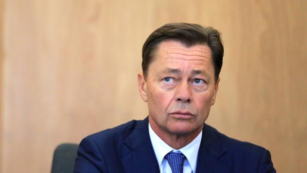 Ein Mann im Anzug blickt aufmerksam zur Seite.