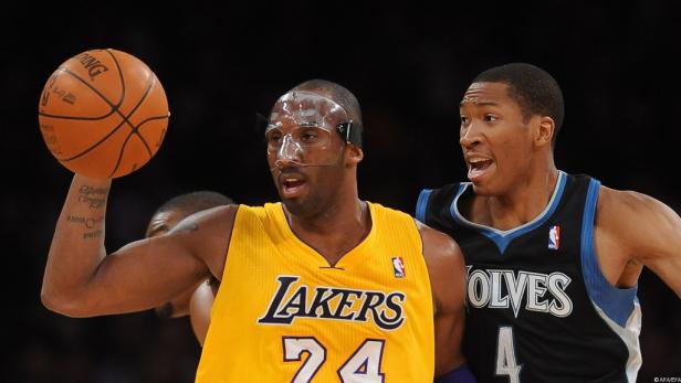 Kobe Bryant von den Lakers mit einer Schutzmaske hält einen Basketball in der Hand.