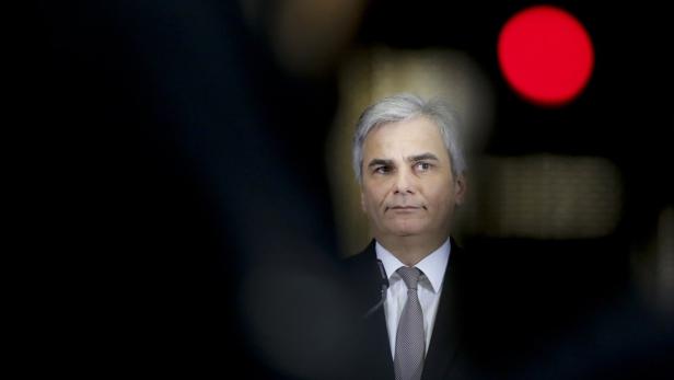 Ein Mann mit grauem Haar und Anzug blickt ernst in die Kamera.