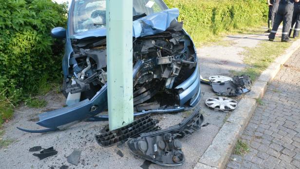 Ein blaues Auto ist nach einem Unfall gegen einen Laternenmast geprallt.
