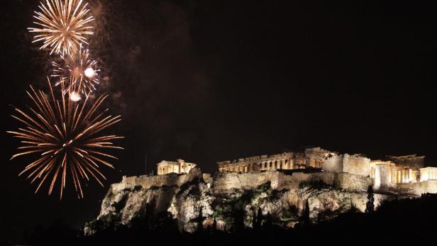 epa03521312 Fireworks explode over the ancient Parthenon temple on the Acropolis Hill during the New Year&#039;s celebrations in Athens, Greece, 01 January 2013. EPA/SIMELA PANTZARTZI
