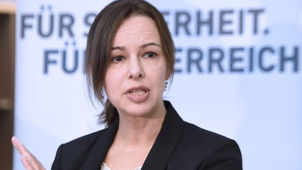 Eine Frau spricht vor einem Hintergrund mit der Aufschrift „Für Sicherheit. Für Österreich.“.