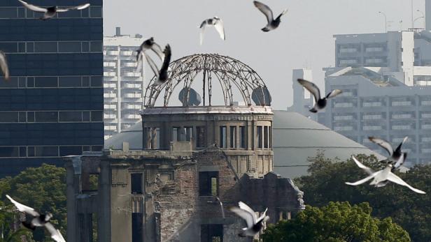 Tauben fliegen vor der Atombombenkuppel in Hiroshima.