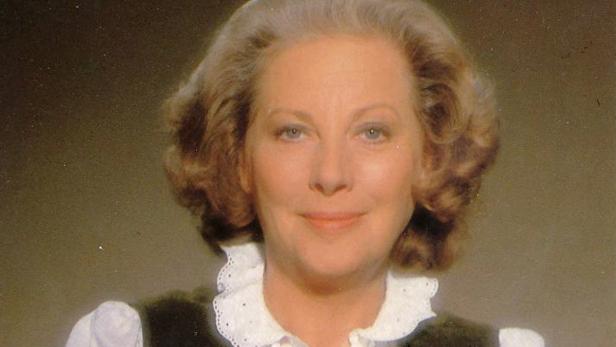 Porträt einer Frau mit hellbraunen, gelockten Haaren und einem weißen Rüschenkragen.