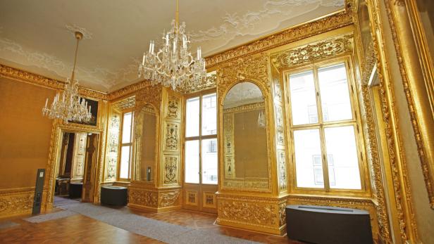 Ein prunkvoller Raum mit goldenen Verzierungen und Kristalllüstern.