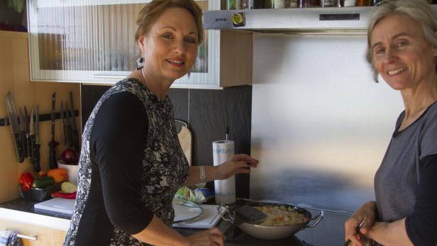 Zwei Frauen kochen gemeinsam in einer Küche.