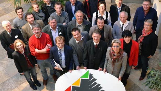 Eine Gruppe von Menschen posiert mit einem Schild der „Eisenstraße“.