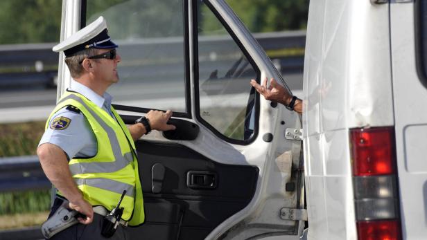 A border police patrol guard speaks with a truck driver near the Schengen border in Krsko July 4, 2011. In December 2007, the European Union lifted land and sea border checks between Slovenia and Italy, Hungary and Austria. Airport checks were also abolished in December 2008 following the signing of the Schengen Agreement. REUTERS/Srdjan Zivulovic (SLOVENIA - Tags: TRANSPORT SOCIETY)