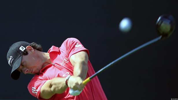 Ein Golfspieler schlägt einen Ball mit einem Driver.