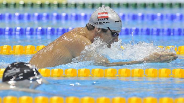 Ein Schwimmer mit Badekappe der österreichischen Nationalmannschaft beim Brustschwimmen.