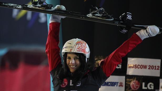 Eine Skifahrerin feiert mit erhobenen Skiern in Moskau 2012.