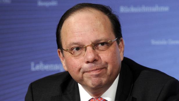 Ein Mann mit Brille und dunklem Anzug blickt in die Kamera.