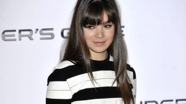 Hailee Steinfeld mit Ponyfrisur und einem schwarz-weiß gestreiften Oberteil.