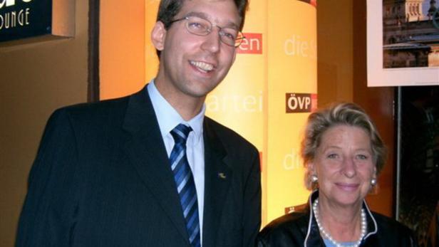Ein Mann und eine Frau posieren vor einem ÖVP-Hintergrund.