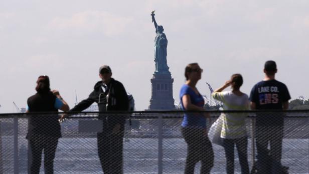 Tourists pause to view the Statue of Liberty from Seit zwei Wochen konnten Besucher die Freiheitsstatue in New York nur aus der Ferne betrachten.