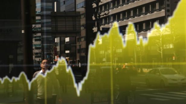 Ein Mann blickt in einer Stadt auf eine gelbe Grafik, die auf eine Glasscheibe projiziert wird.