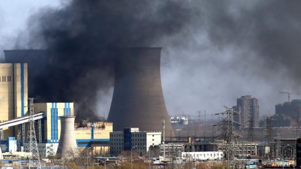 Schwarzer Rauch steigt aus einem Kraftwerk auf.