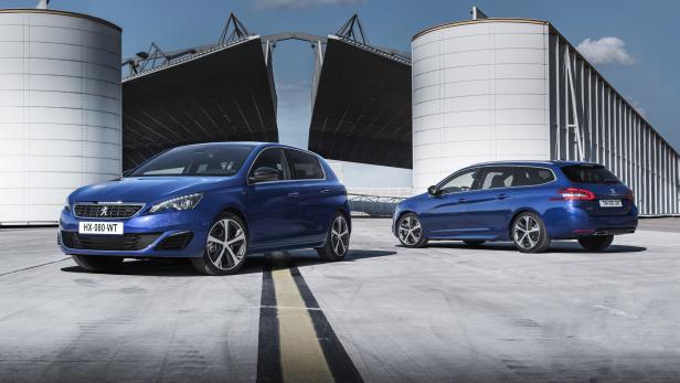 Zwei blaue Peugeot 308 Modelle vor einem modernen Gebäude.