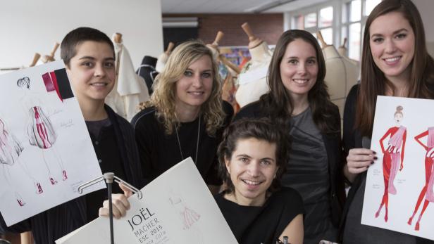 Eine Gruppe junger Modedesigner präsentiert ihre Entwürfe auf Papier.